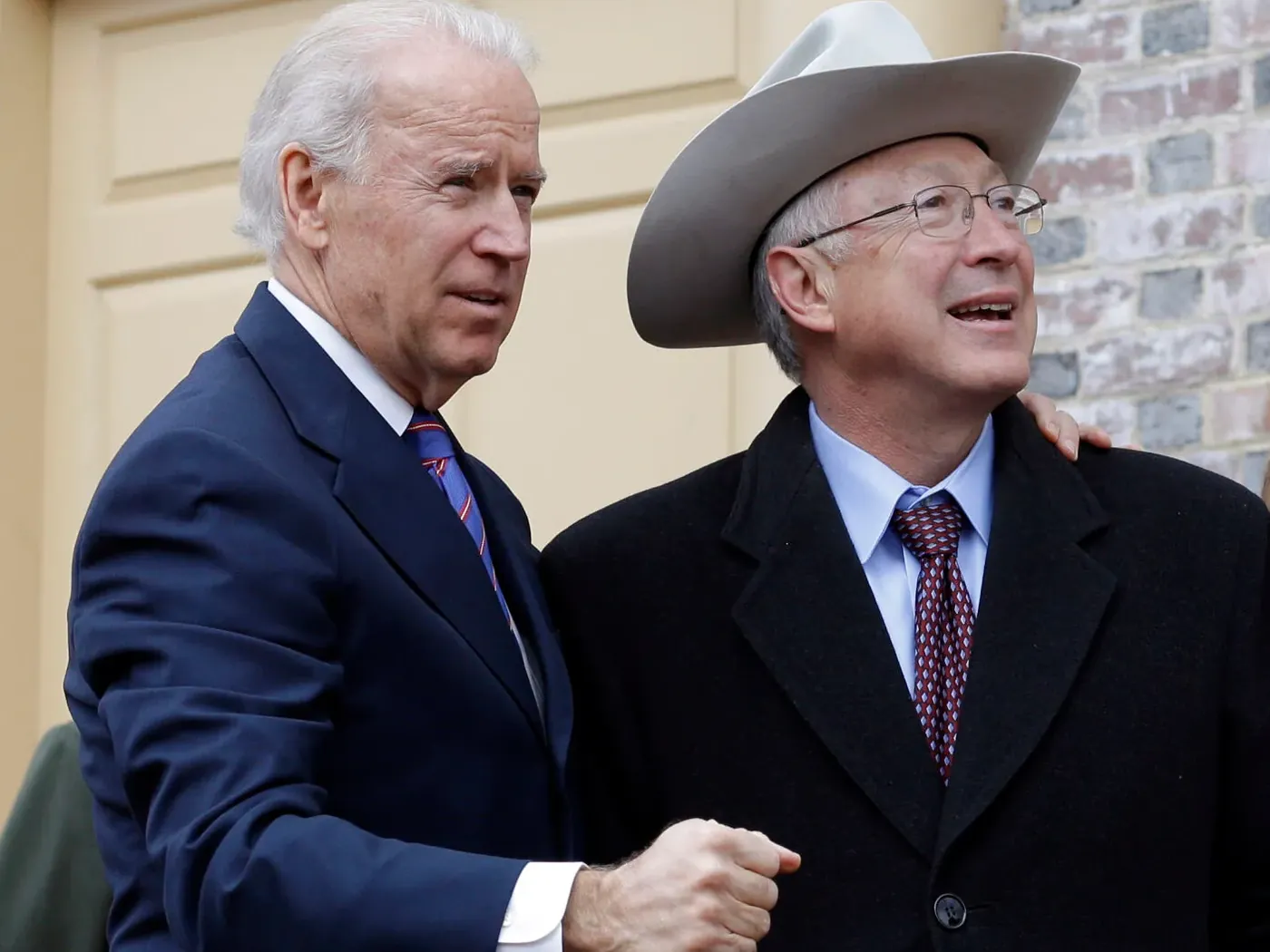 Ken Salazar in his hat, looking up and smiling, with Joe Biden’s arm around his shoulder